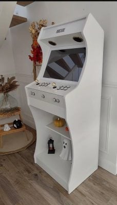 Arcade King blanche avec piédestal incurvé, joysticks à boule dorée et boutons translucides lumineux, l'étagère du piédestal décorée pour Halloween
