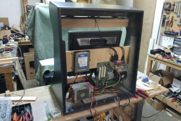 Bartop arcade visto por detrás con un PC montado dentro, en el taller